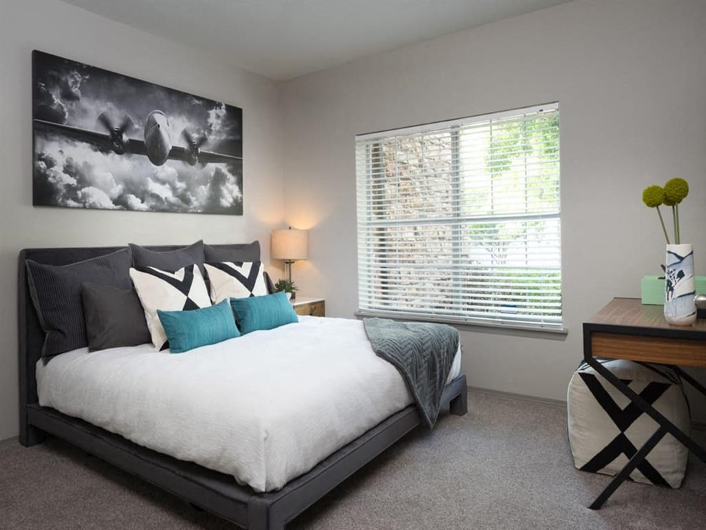 a bedroom with a large bed and a window