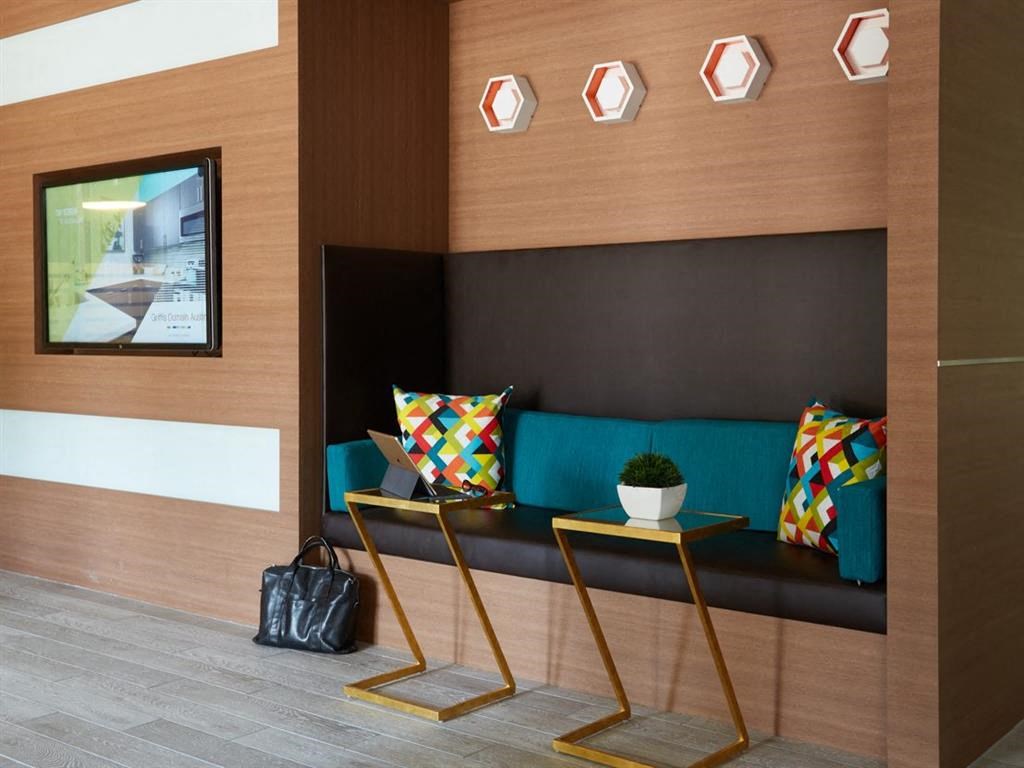 a seating area in a hotel lobby with a couch and tables