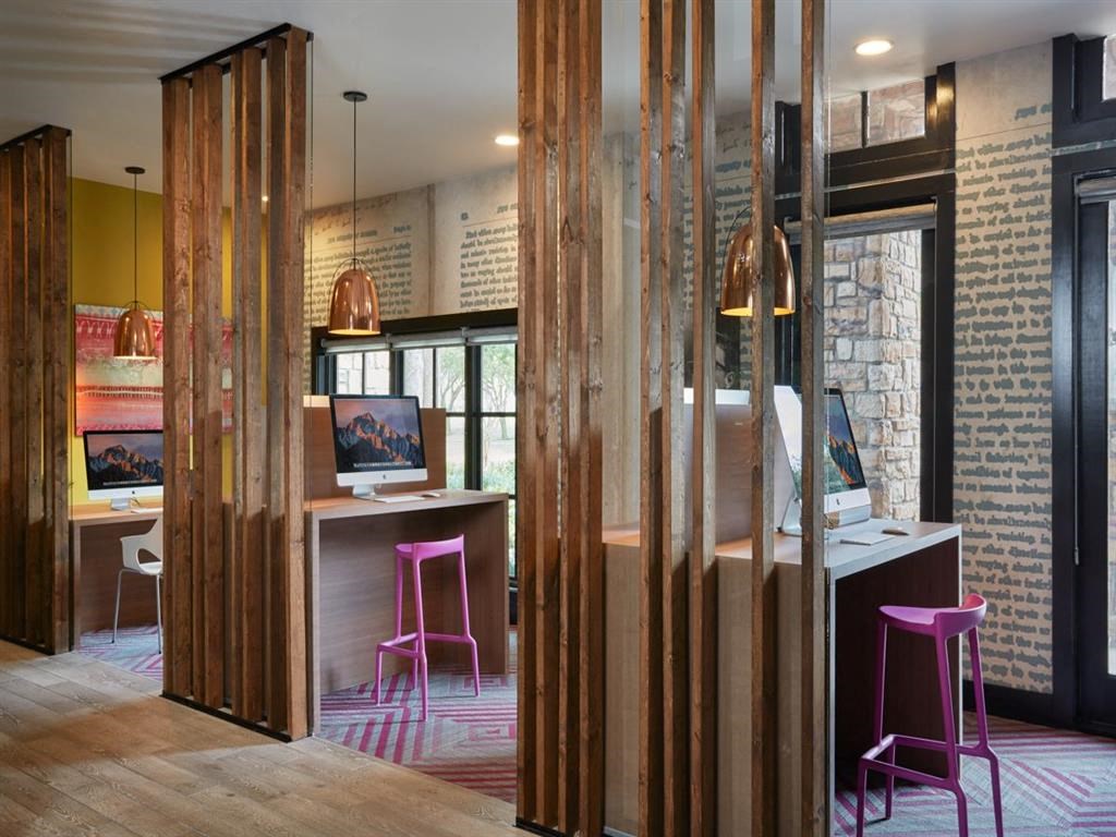 a bar with pink stools in a room with a brick wall