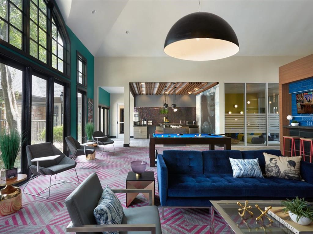 a living room with a blue couch and a pool table