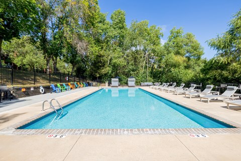 Apartments in Eden Prairie, MN, with In-Unit Washer and Dryer - The Park at City West - Outdoor Swimming Pool With Lounge Chairs, Turquoise Water, Tree-Lined Sundeck, And Clear Blue Sky.