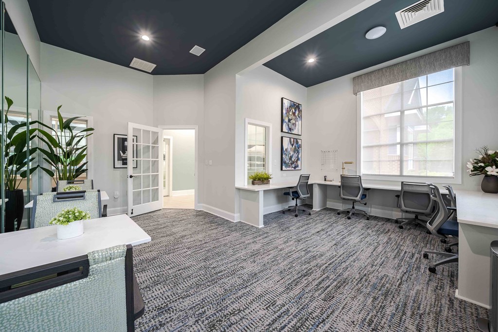 an office with desks and chairs and a large window