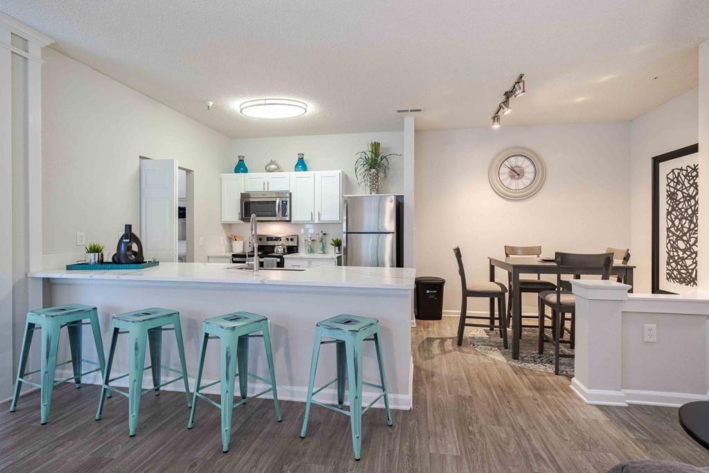 an open kitchen and dining room with blue stools