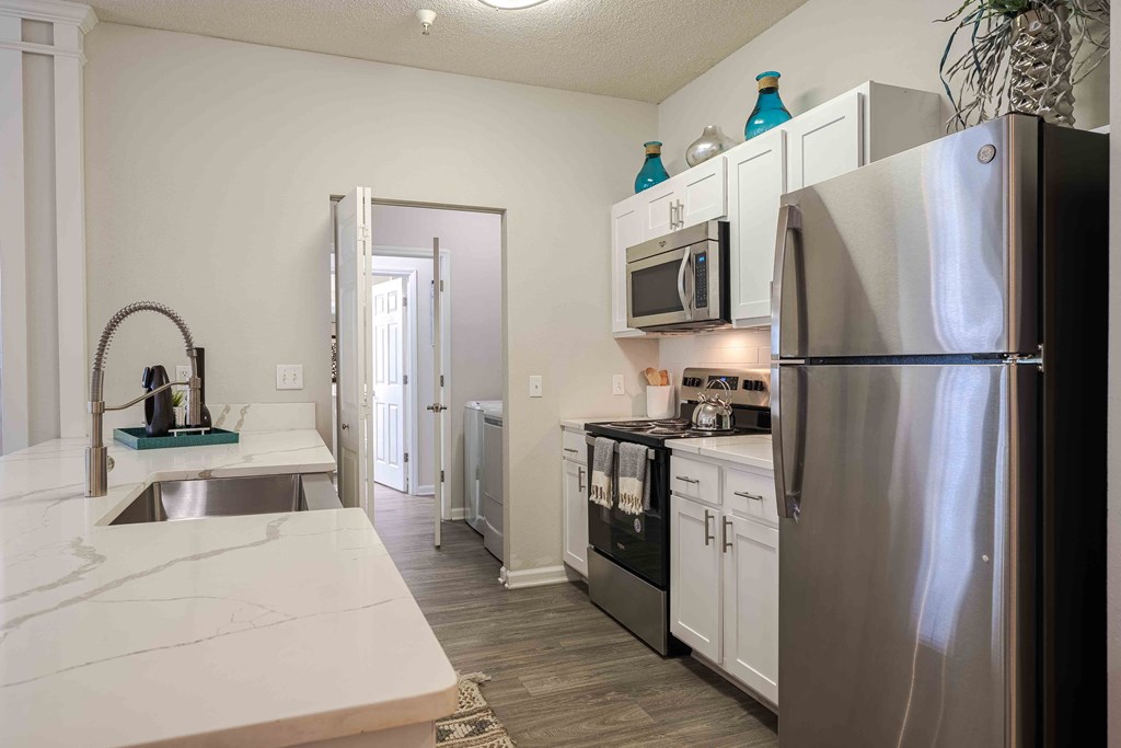 a kitchen with stainless steel appliances and white cabinets