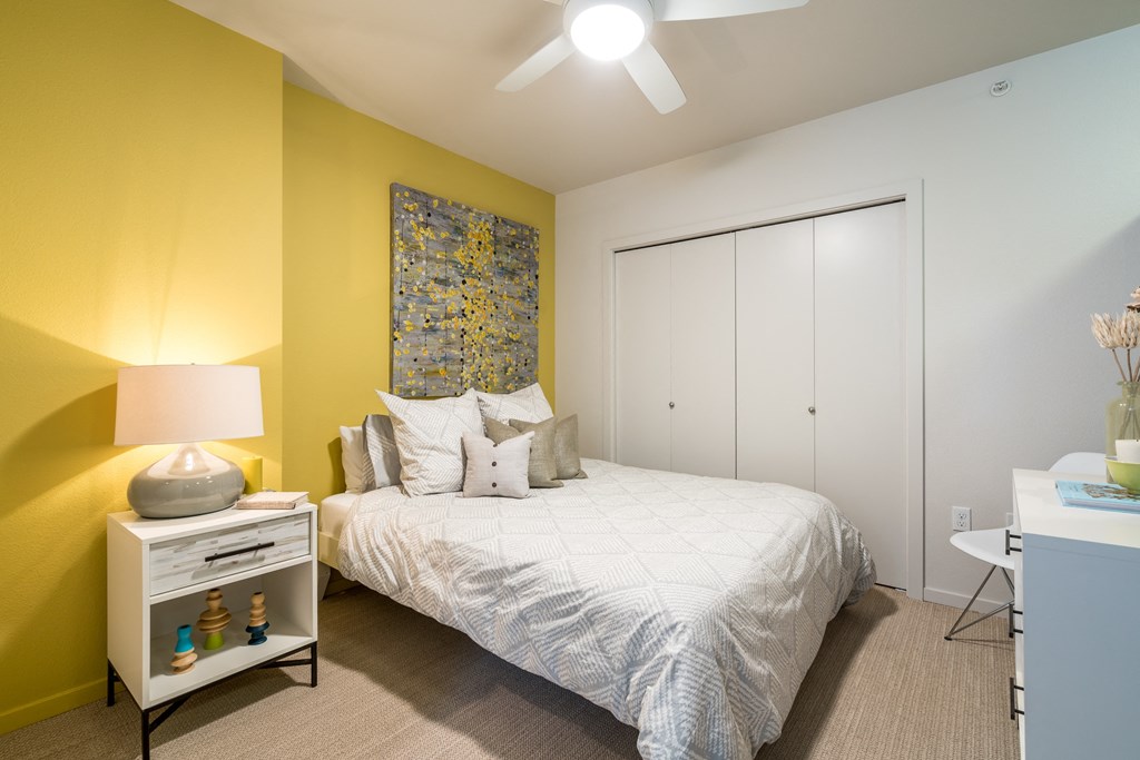 a bedroom with yellow walls and a white bed