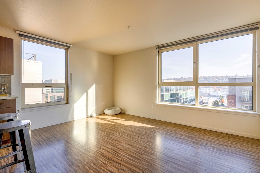 a living room with wood floors and large windows