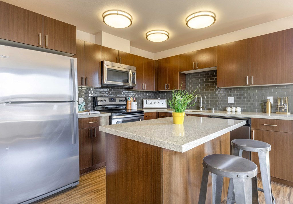 a kitchen with stainless steel appliances and a marble counter top