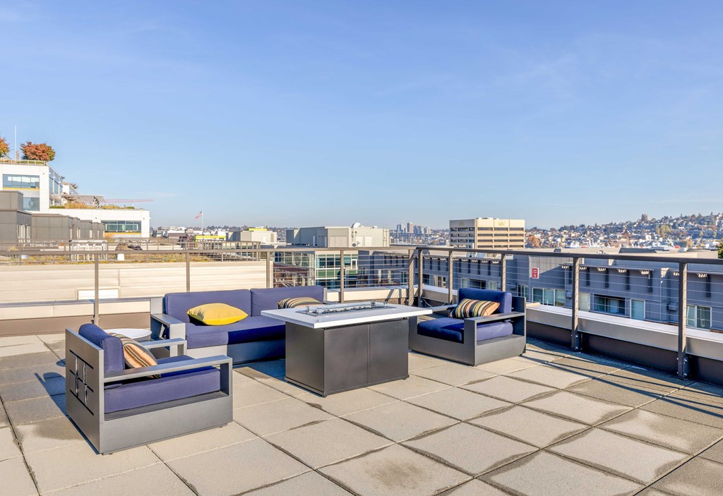a terrace with couches and a table on a roof overlooking the city