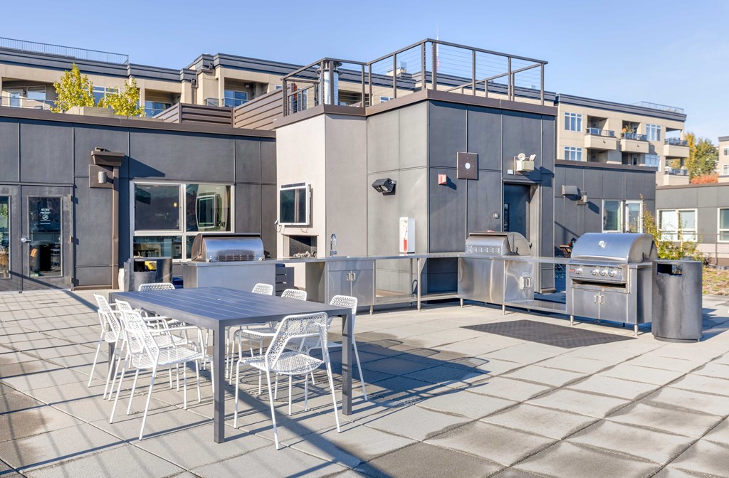 a patio with a table and chairs on the rooftop
