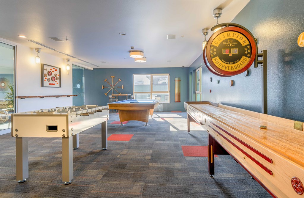 a game room with a pool table and shuffleboard
