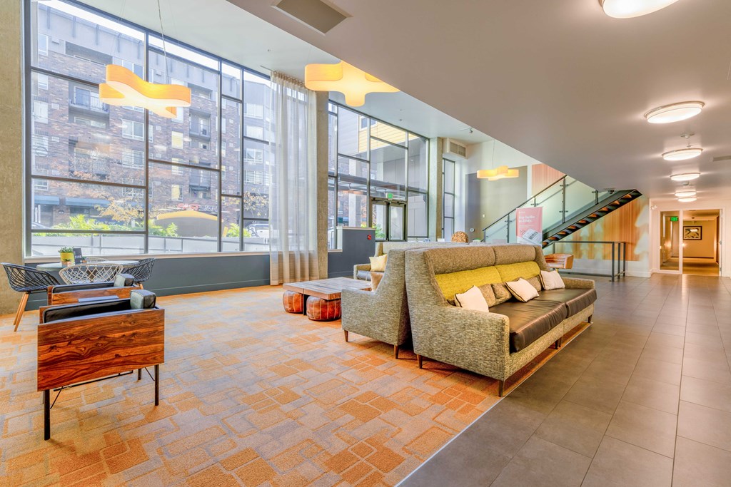 a living room with a couch and a table and large windows