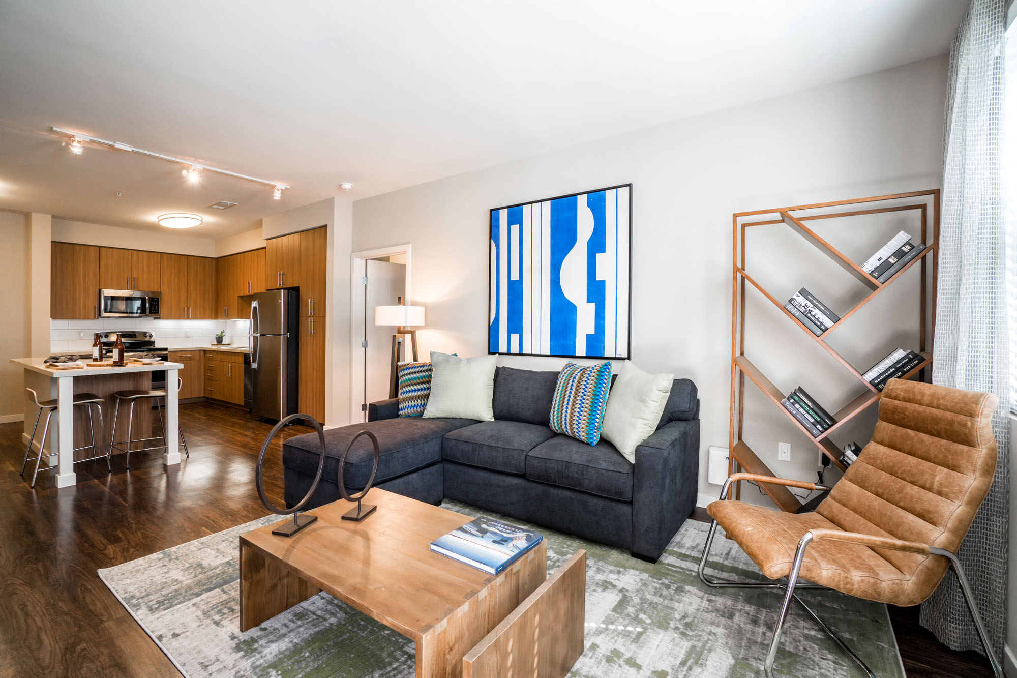 Santa Clara, CA, Apartments For Rent - Villas On The Boulevard - Living Room With Wood-Inspired Flooring, Windows, Modern Fixtures, And Access To Kitchen