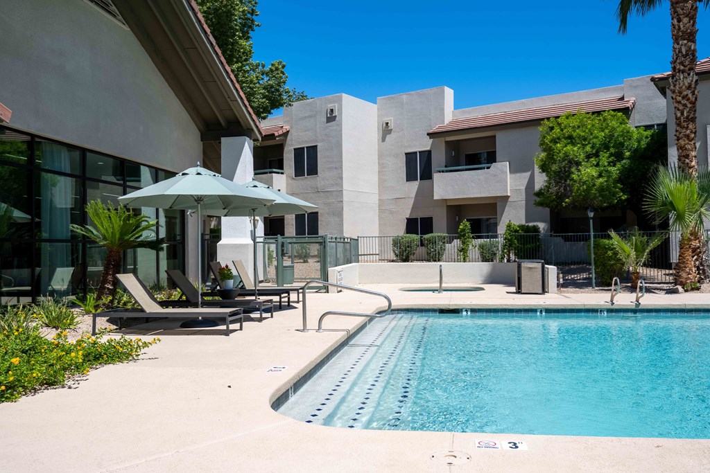 South Phoenix Apartments - Village at Lakewood - Sparkling Pool with Sun Lounge Chairs, Umbrellas, Hot Tub, and Palm Trees