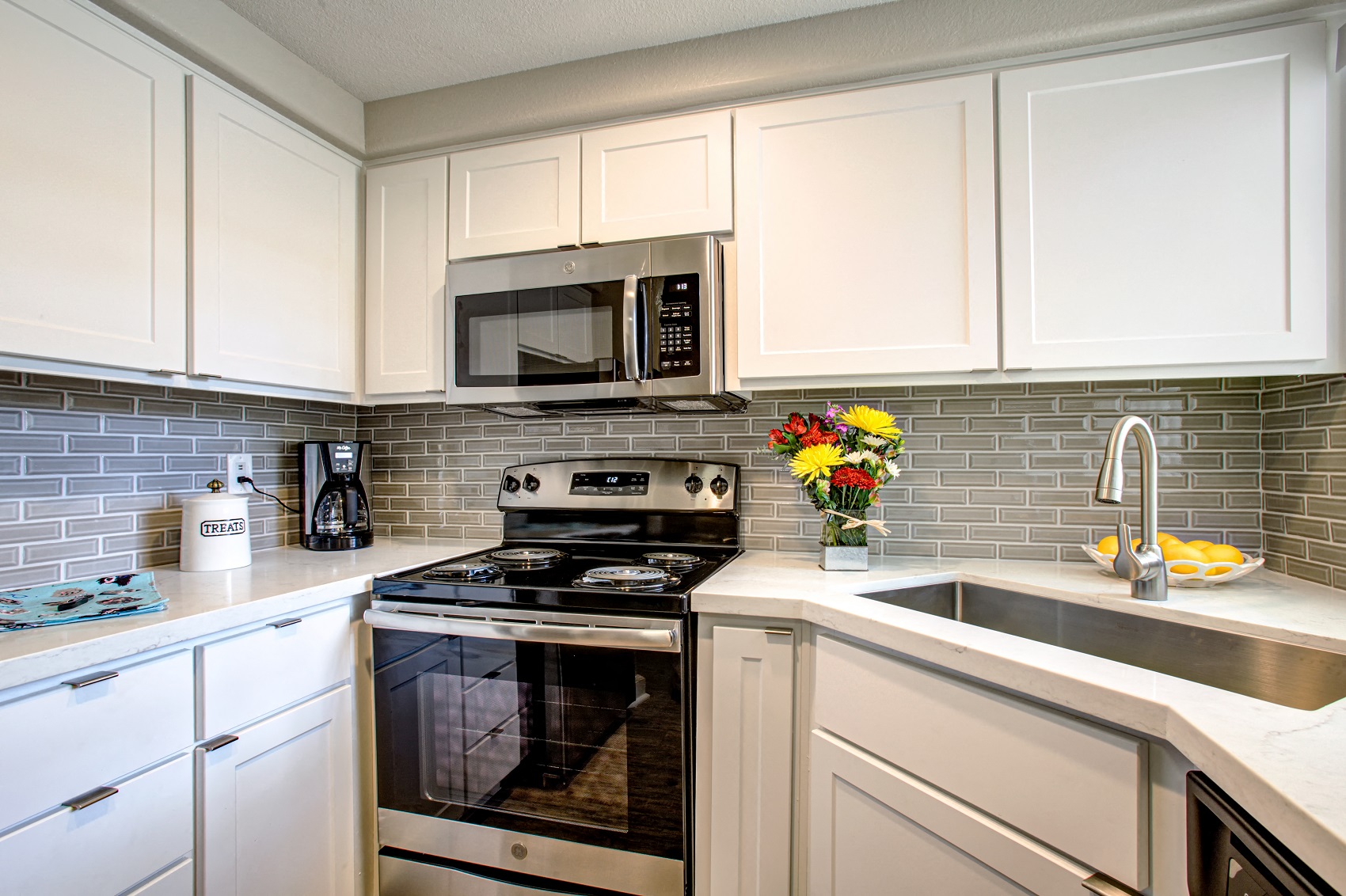 Apartments in Phoenix, AZ - Village at Lakewood Fully Equipped Kitchen with Stainless Steel Appliances and White Cabinetry