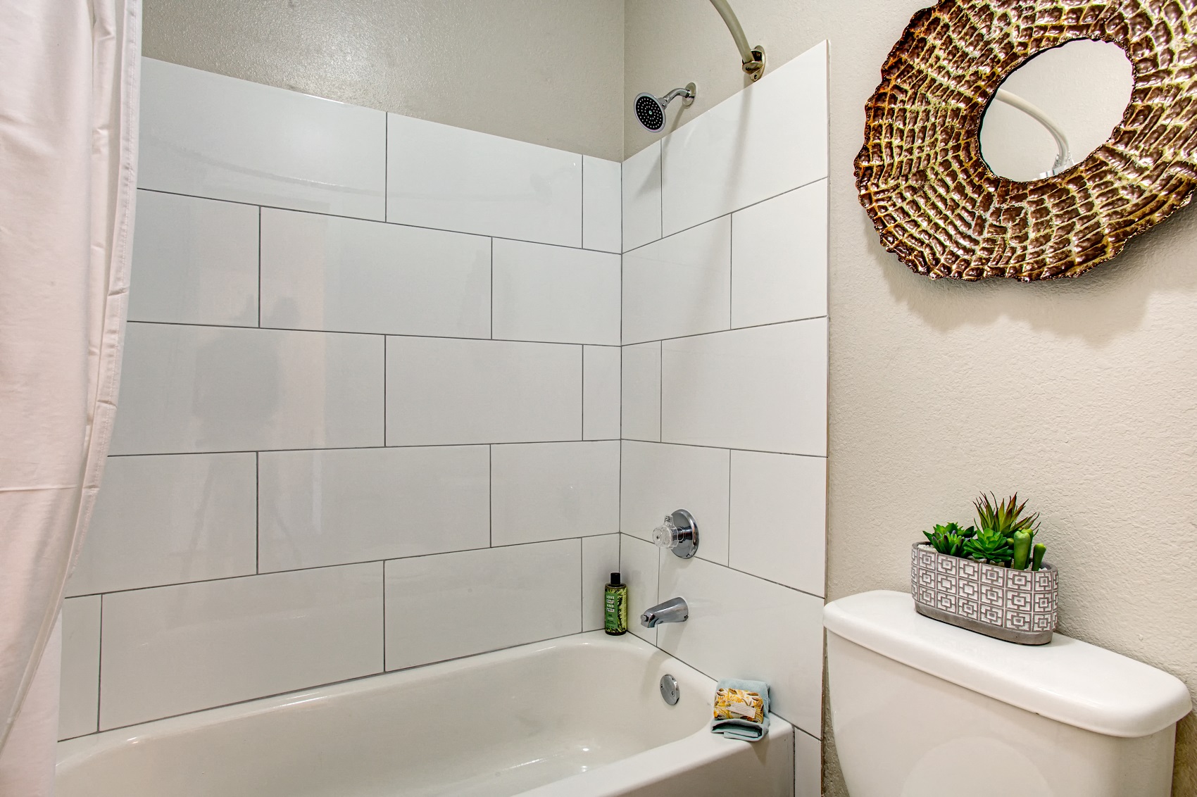 Apartments for Rent in South Phoenix - Village at Lakewood - Bathroom with Bathtub, Circle Mirror, and White Tiles