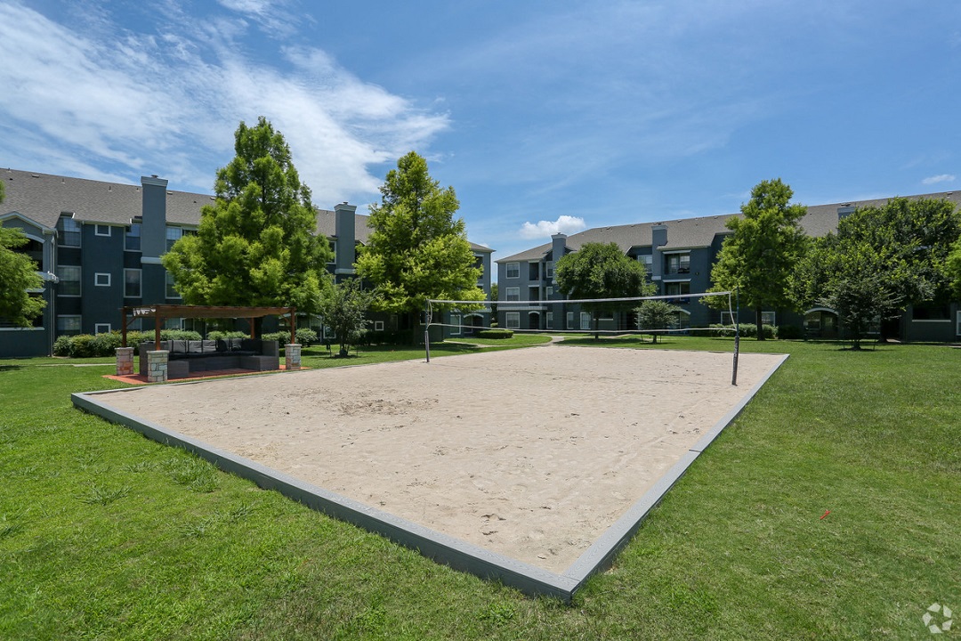a sand volleyball court in front of an apartment building