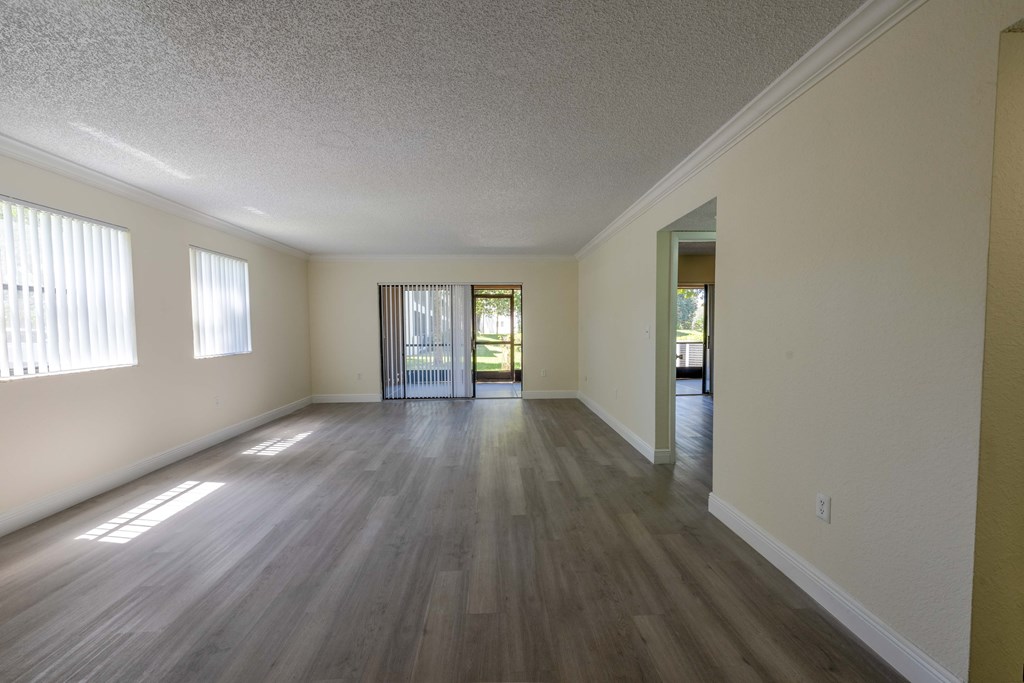 Coconut Creek Apartments – Waterview at Coconut Creek – empty living room with wood flooring and a door to a patio