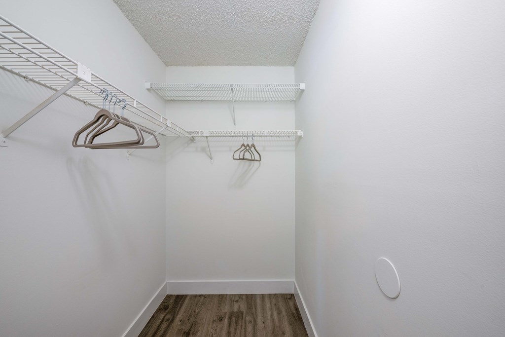 Coconut Creek Apartments – Waterview at Coconut Creek – empty closet with white walls and white hangers in a white room with wood