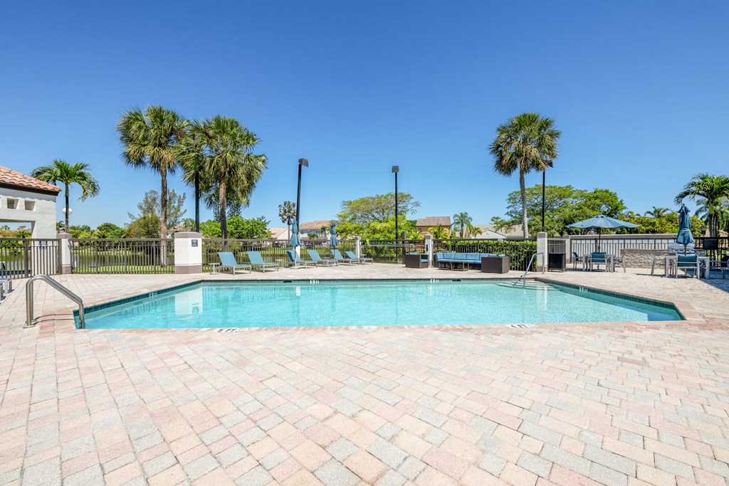 Pet-Friendly Apartments in Coconut Creek, FL – Waterview at Coconut Creek – resort style swimming pool and sundeck with palm trees behind
