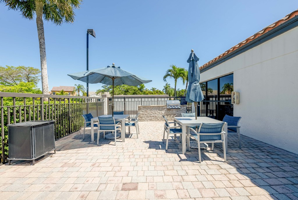 Coconut Creek Apartments – Waterview at Coconut Creek – patio with tables and chairs and umbrellas