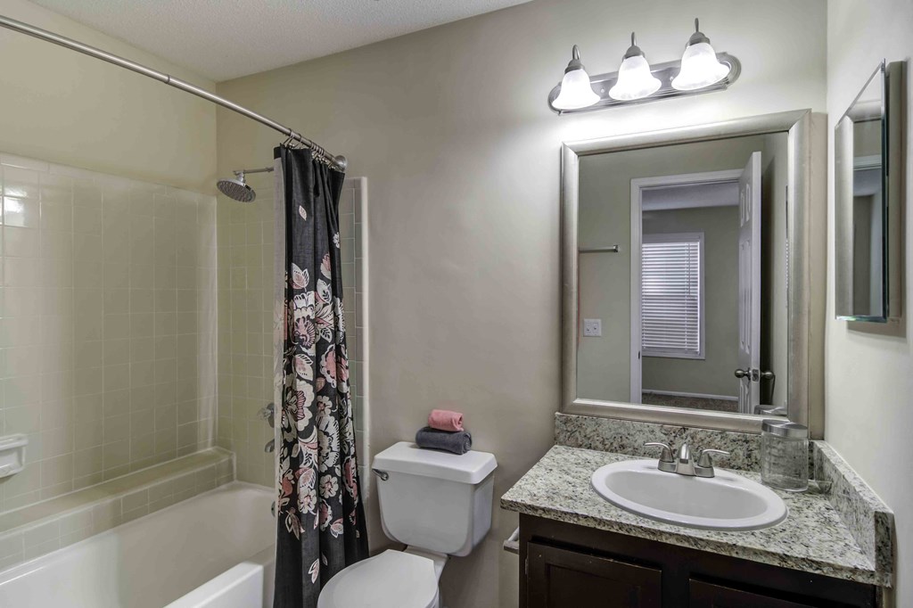 Wood Pointe Apartment Homes in Marietta Georgia photo ofa bathroom with granite counter tops a shoer and a toilet