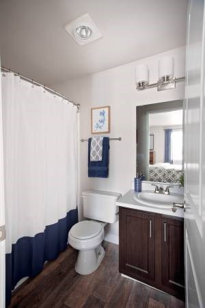 A white toilet sits in a bathroom next to a sink.