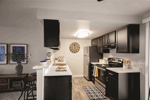 A black and white kitchen with a clock on the wall.