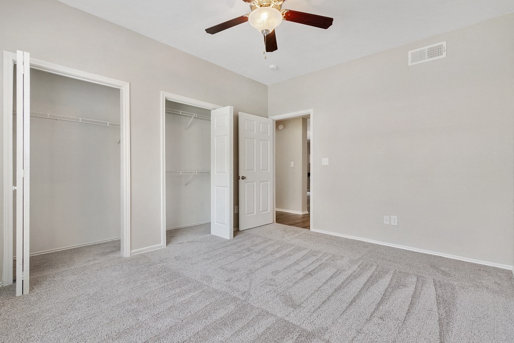 Spacious floor plans Luxury One Bedroom Apartments in Plano, TX - Carrington Park Apartments Bedroom With Ceiling Fan, Plush Carpeting and Large Closets