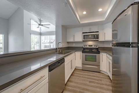 Apartments for Rent in San Clemente - Rancho Del Mar - Kitchen with Stainless Steel Appliances, Hardwood-Inspired Flooring, and White Cabinetry