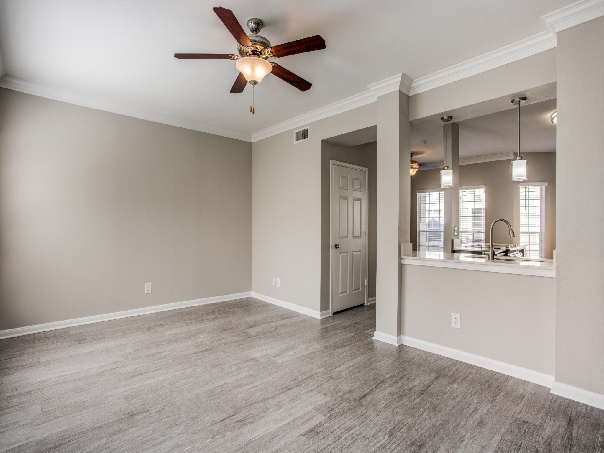 Apartments in Houston - The Maroneal Open Layout Living Room With Hardwood Style Flooring Ceiling Fan and Modern Finishes