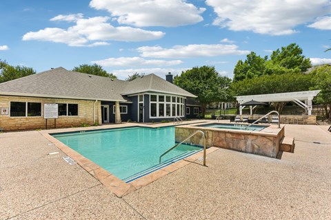 A pool with a slide and a building behind it.