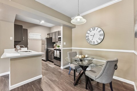 A dining room with a glass table and chairs.