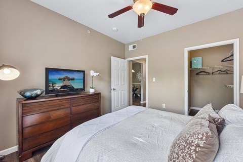 A bedroom with a large bed and a ceiling fan.