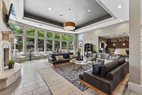 A modern living room with a stone fireplace and a large window.