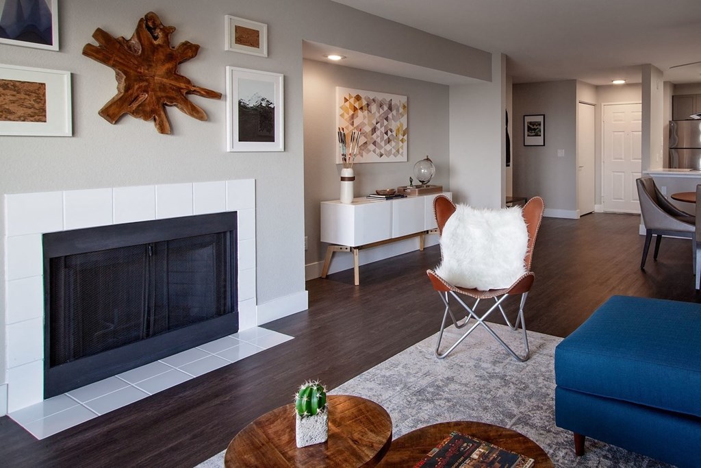 Apartments for Rent in Mountain Park - MiLO at Mountain Park - Living Room with Wood-Style Flooring, Area Rug, Coffee Table, Chair, and Fireplace