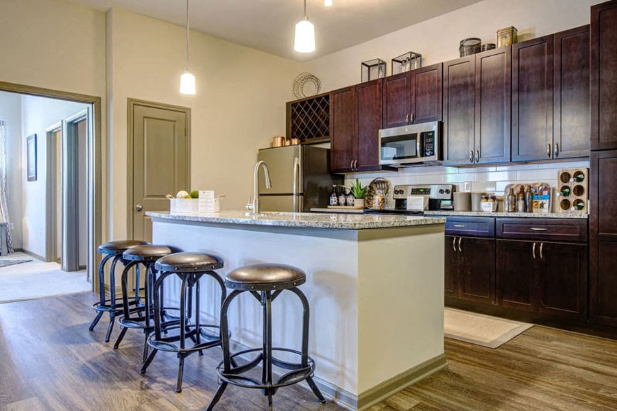 a kitchen with a counter and three stools