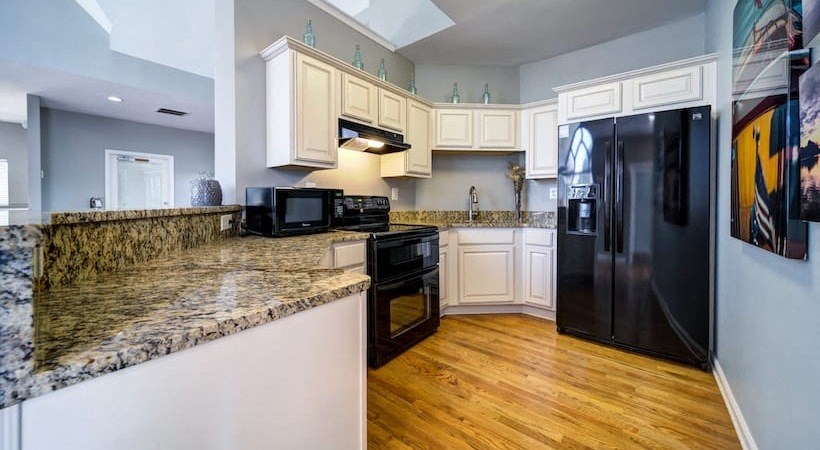 a kitchen with granite counter tops and a black refrigerator
