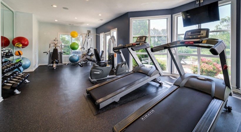 the gym is equipped with cardio equipment and a large window