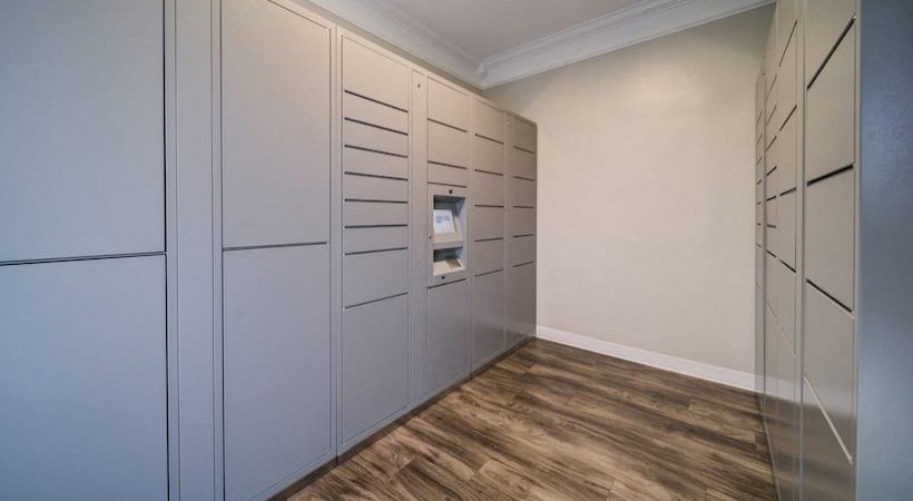a walk in closet with white cabinets and a wood floor