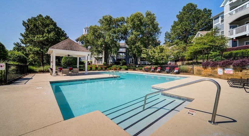 a swimming pool with a gazebo next to a building