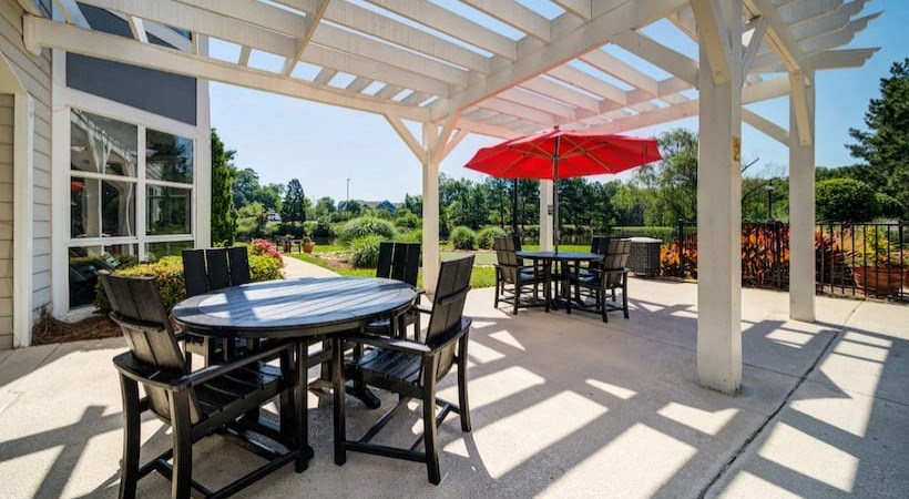 a patio with a table and chairs and an umbrella