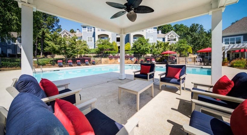 a swimming pool with chairs and a ceiling fan