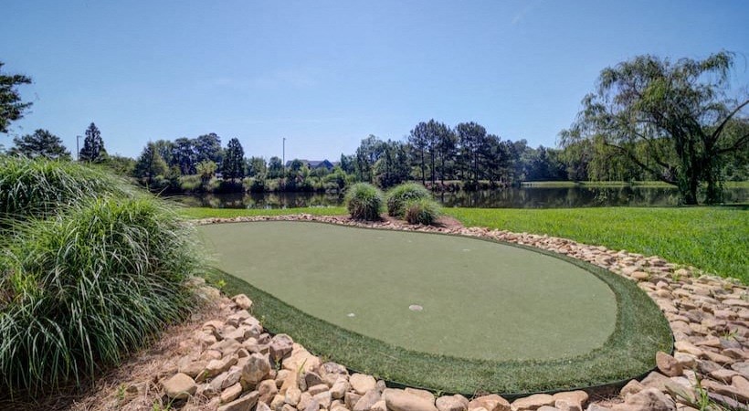 a mini golf course with a lake in the background