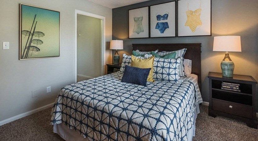 a bedroom with a bed and paintings on the wall