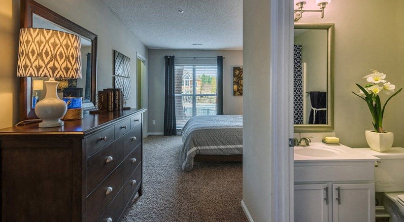 a bedroom with a bed and a sink and a mirror