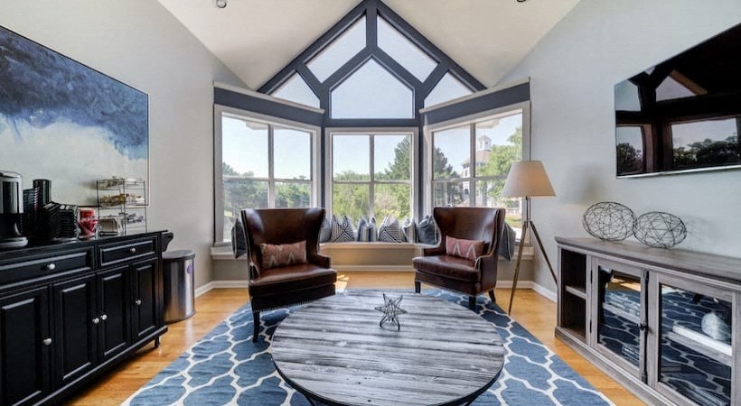 a living room with a table and chairs and a large window