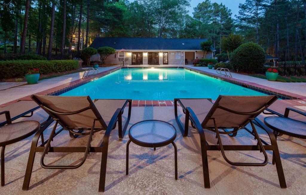 Pet-Friendly Apartments in Alpharetta, GA – Webb Bridge Crossing – swimming pool at dusk with patio chairs