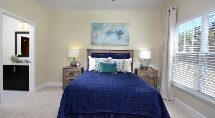 Durham Apartments - 54 Station - Spacious Bedroom with Plush Carpets, Large Windows, Ceiling Fan, and Window Coverings