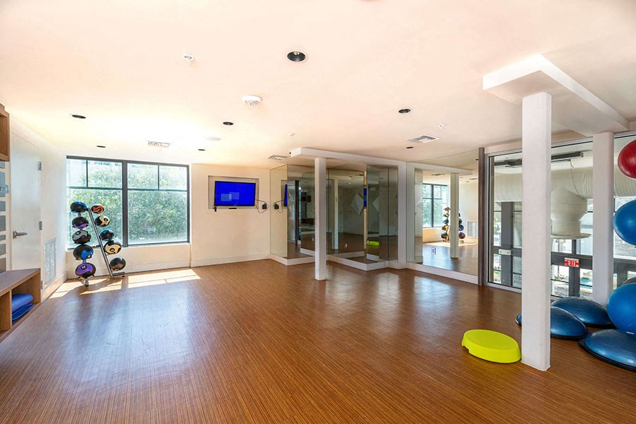 The Edge at Flagler Village Apartments in Fort Lauderdale, FL photo of a gym with a wooden floor and a large window