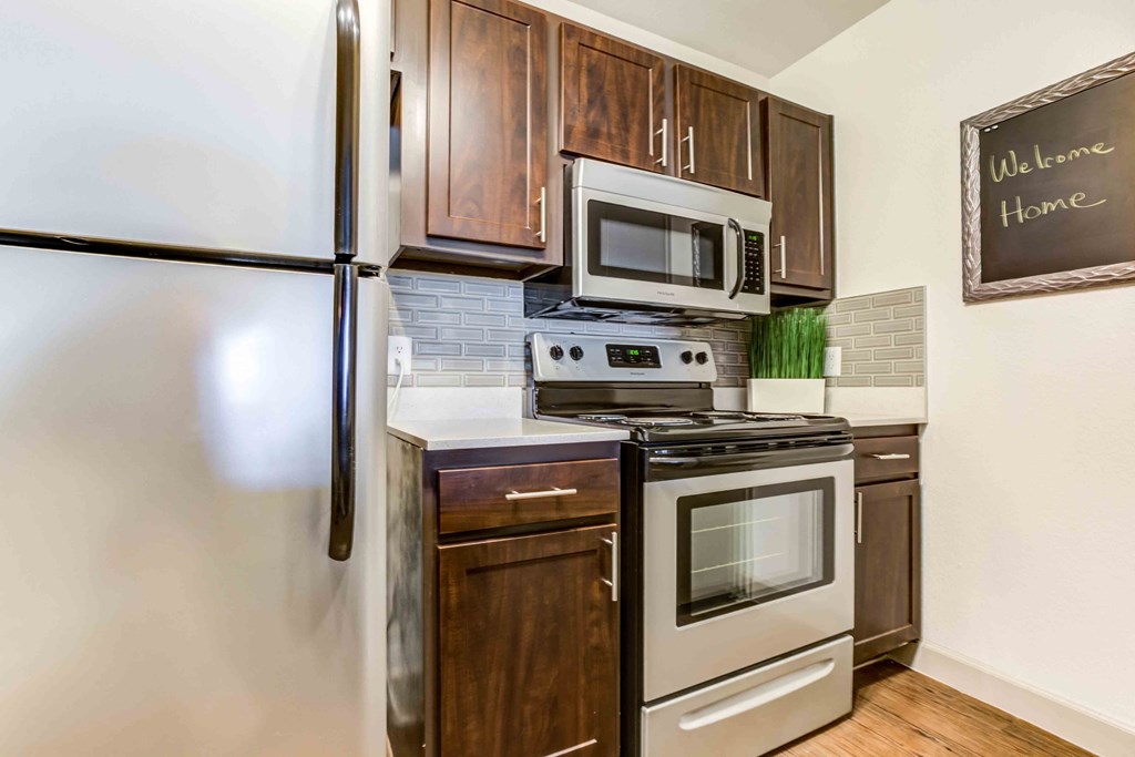a kitchen with stainless steel appliances and wooden cabinets